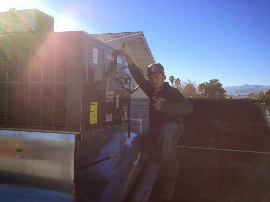 HVAC technician performing AC Tune-Up on a rooftop unit in Richland Hills